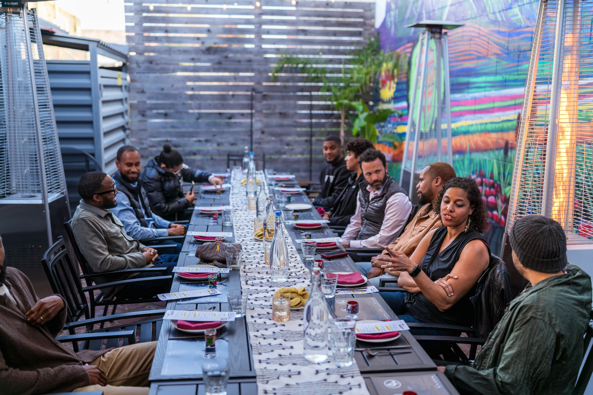 A long table set for conversation, with people gathered together